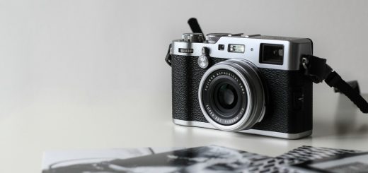 black and gray film camera near printed photos