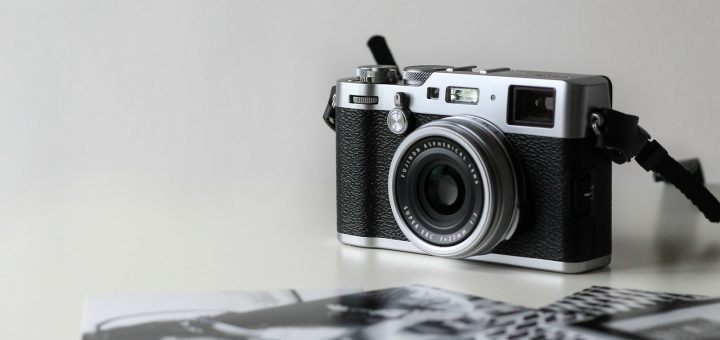 black and gray film camera near printed photos